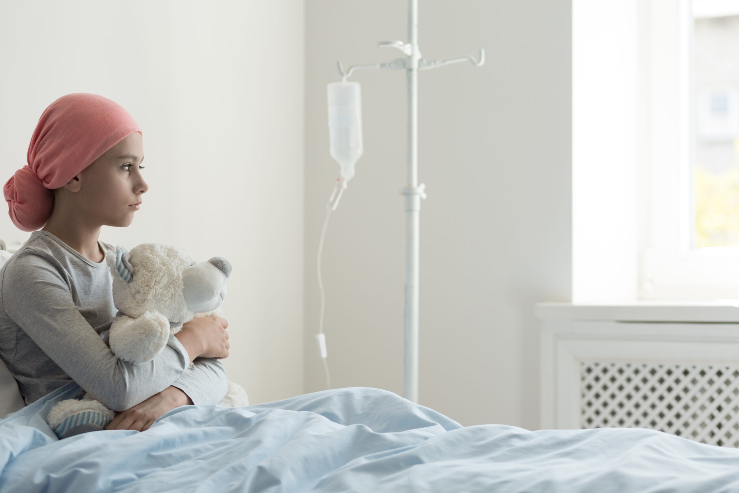 Lonely sick girl wearing headscarf and hugging plush toy in the Lonely sick girl wearing headscarf and hugging plush toy in the hospital